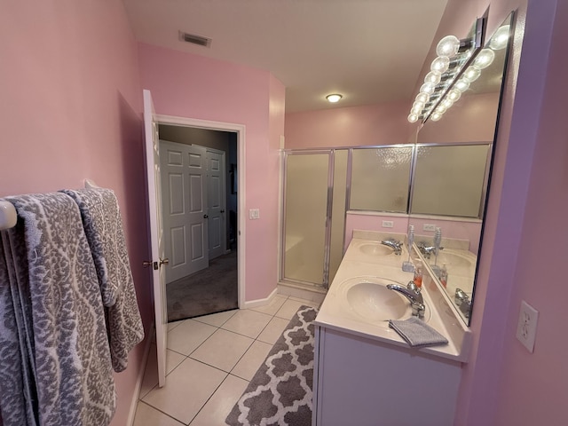 bathroom featuring tile patterned floors, vanity, and a shower with shower door