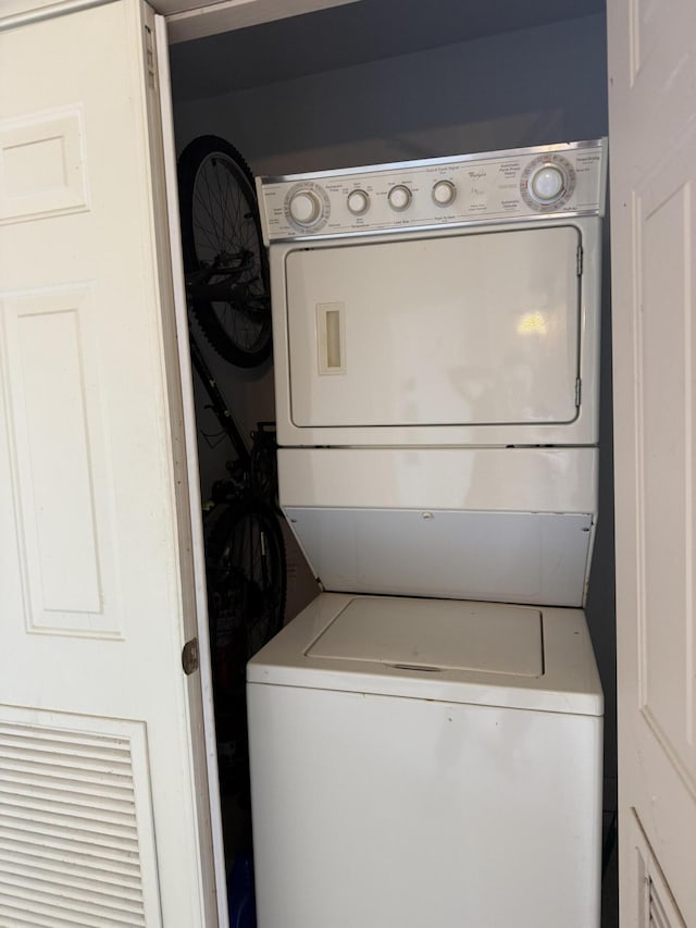 washroom featuring stacked washing maching and dryer