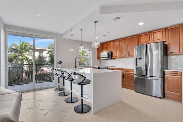 kitchen with a center island with sink, decorative backsplash, sink, and appliances with stainless steel finishes