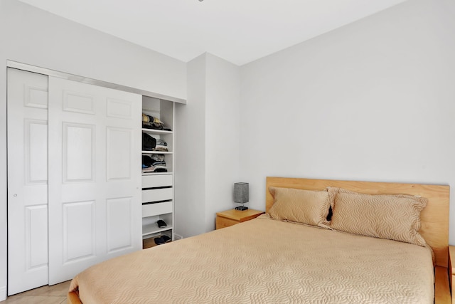 bedroom with light tile patterned floors and a closet