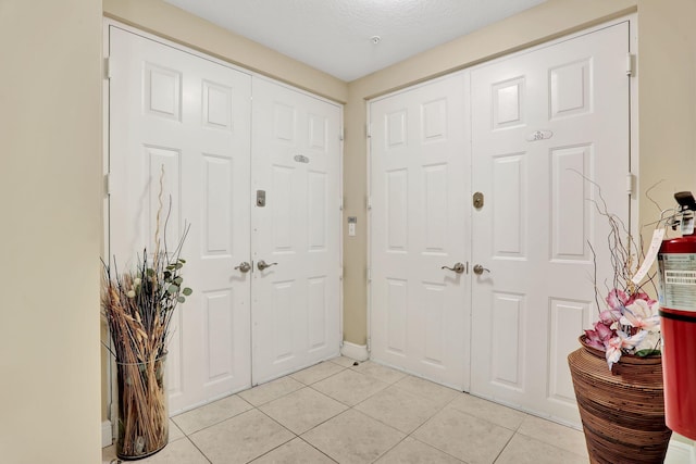 entrance foyer with light tile patterned floors and a textured ceiling