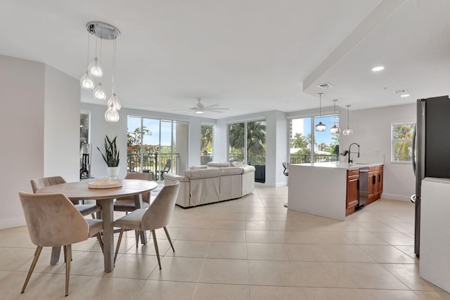 dining room featuring light tile patterned flooring, ceiling fan, and sink