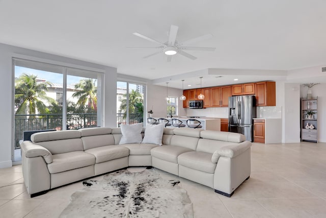 tiled living room featuring ceiling fan and sink