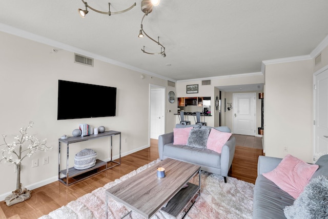 living room with wood-type flooring and ornamental molding