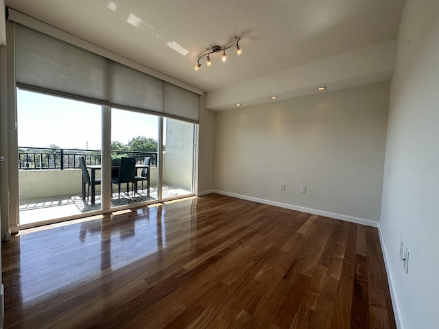 unfurnished room featuring wood-type flooring and a textured ceiling