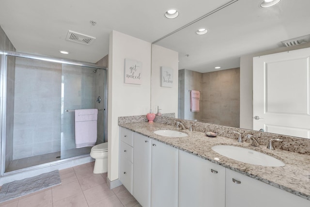 bathroom with tile patterned flooring, vanity, a shower with door, and toilet