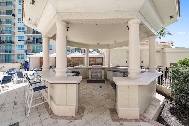 view of patio featuring area for grilling, an outdoor kitchen, an outdoor bar, and a gazebo