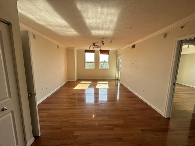 unfurnished room featuring crown molding, dark wood-type flooring, and a textured ceiling