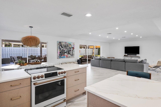 kitchen featuring light brown cabinetry, high end stove, a textured ceiling, and hanging light fixtures