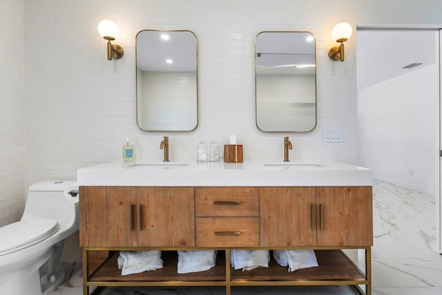 bathroom featuring vanity, toilet, and tile walls