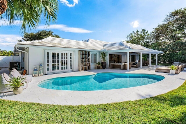 view of swimming pool featuring outdoor lounge area, a patio, and french doors