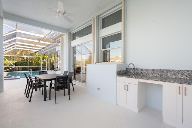 sunroom / solarium featuring lofted ceiling with beams, ceiling fan, and sink