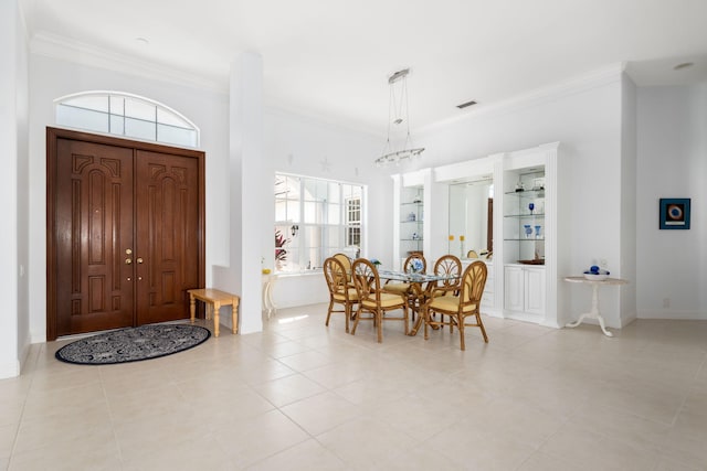 foyer entrance with crown molding and light tile patterned floors