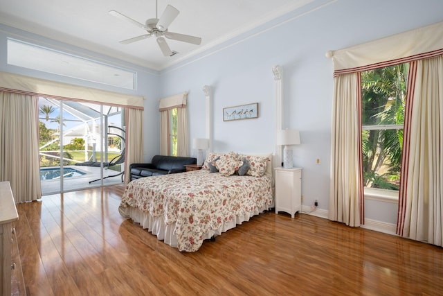 bedroom with multiple windows, hardwood / wood-style floors, access to outside, and ceiling fan