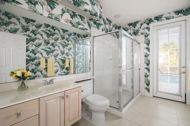 bathroom featuring tile patterned flooring, vanity, toilet, and walk in shower