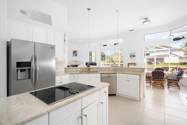 kitchen with stainless steel appliances, sink, pendant lighting, white cabinetry, and light tile patterned flooring