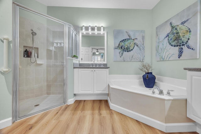 bathroom featuring hardwood / wood-style floors, vanity, and shower with separate bathtub