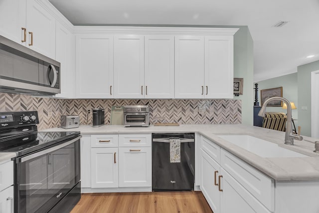 kitchen with backsplash, sink, white cabinets, and appliances with stainless steel finishes