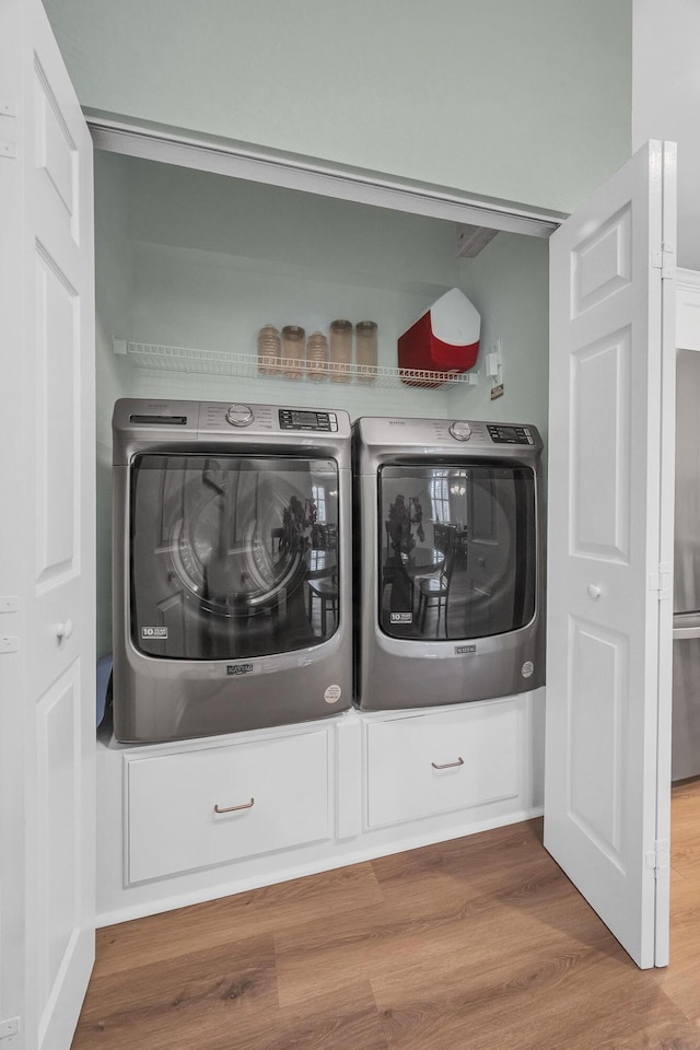 washroom featuring hardwood / wood-style flooring and washing machine and dryer