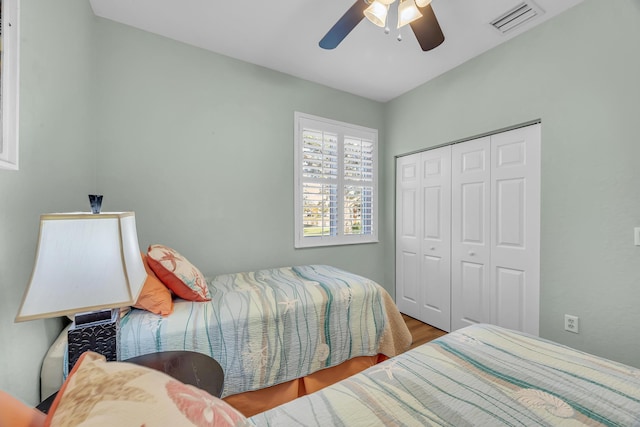 bedroom with ceiling fan, a closet, and wood-type flooring