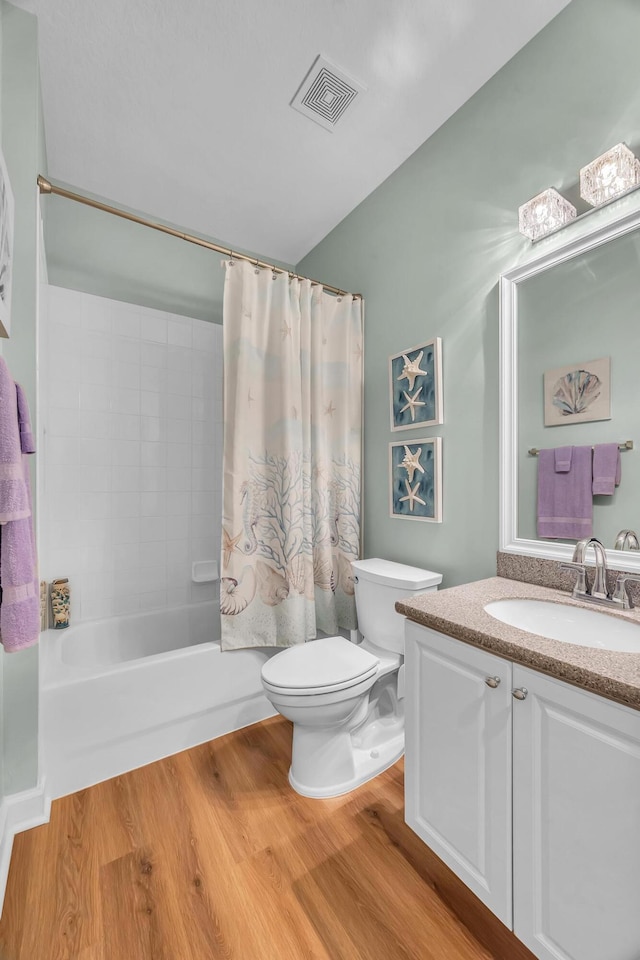 full bathroom with hardwood / wood-style floors, vanity, shower / bath combo, and toilet