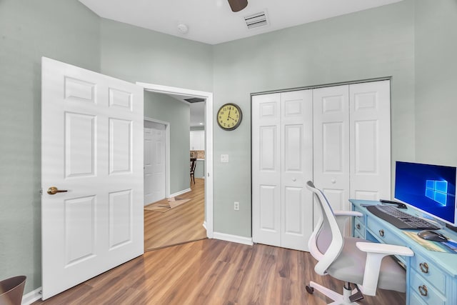 home office with dark hardwood / wood-style floors and ceiling fan