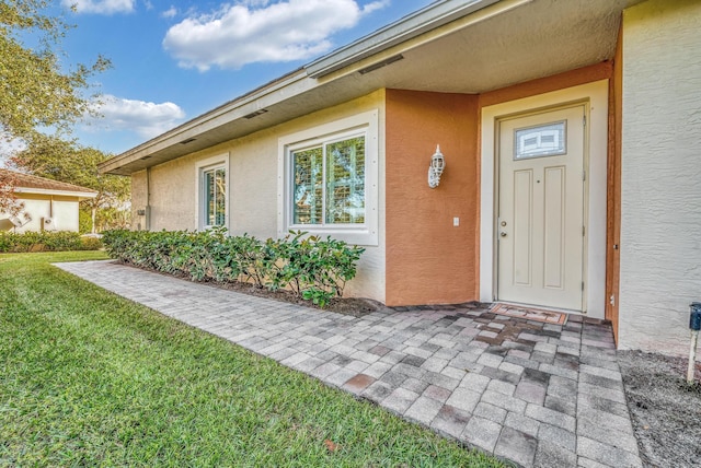 property entrance with a yard