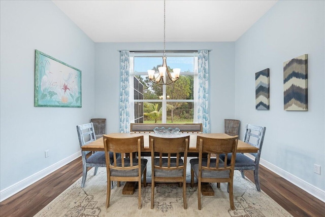 dining area with wood-type flooring and an inviting chandelier