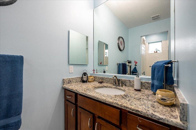 bathroom featuring a textured ceiling and vanity