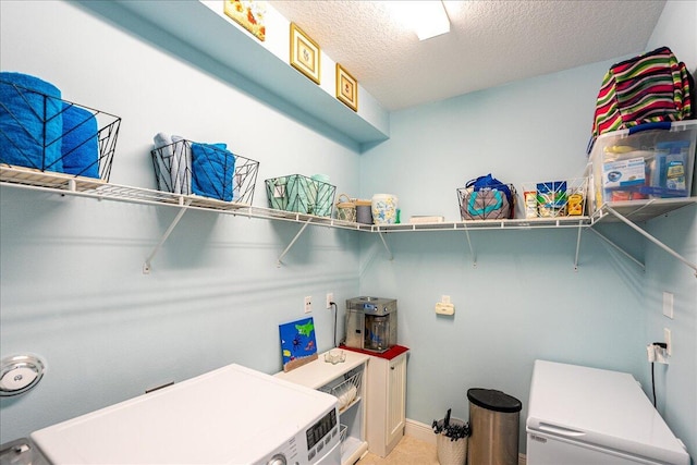 laundry area featuring washer / clothes dryer and a textured ceiling