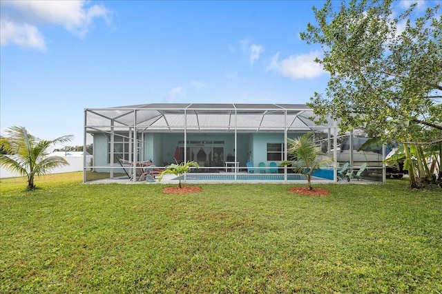 back of house with a lanai and a yard