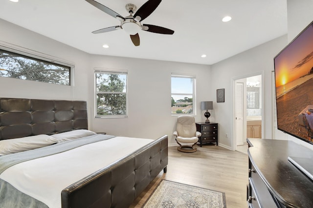 bedroom with ceiling fan, ensuite bathroom, and light hardwood / wood-style flooring