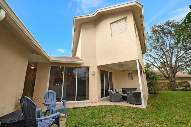 back of property with ceiling fan, a yard, an outdoor hangout area, and a patio