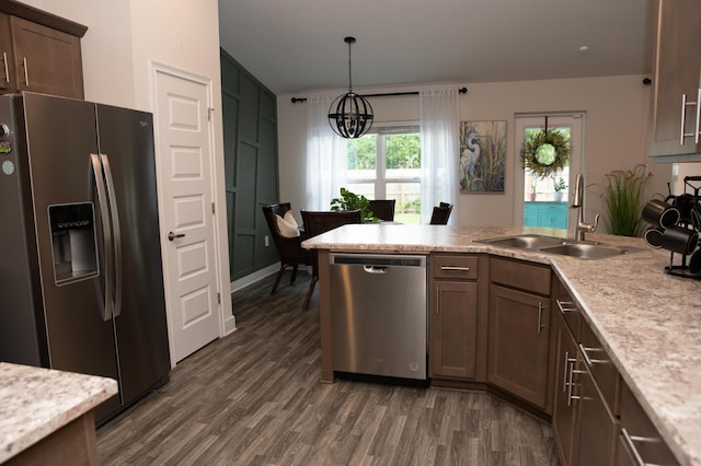 kitchen featuring sink, decorative light fixtures, dark hardwood / wood-style flooring, stainless steel appliances, and a chandelier