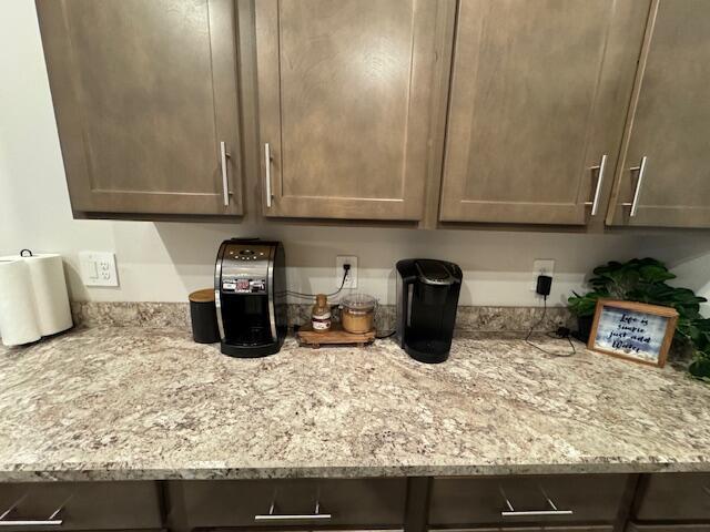 kitchen with light stone countertops and dark brown cabinets