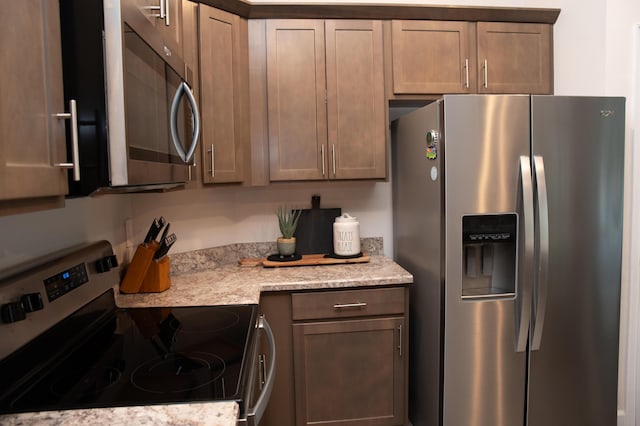 kitchen featuring light stone countertops and stainless steel appliances