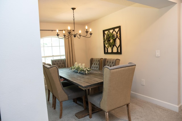 dining room with carpet and a notable chandelier