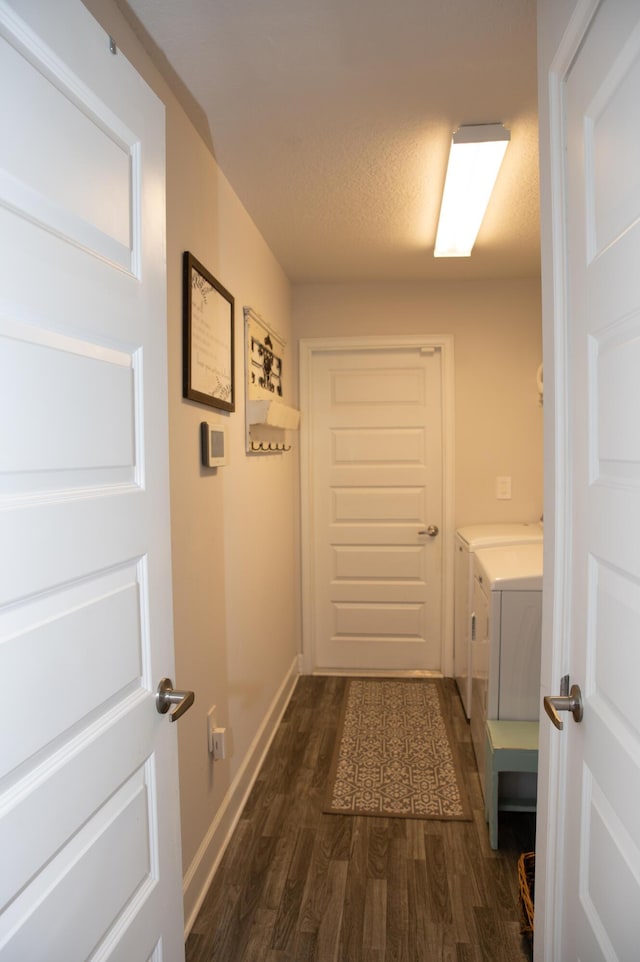 hall with a textured ceiling, dark hardwood / wood-style floors, and independent washer and dryer