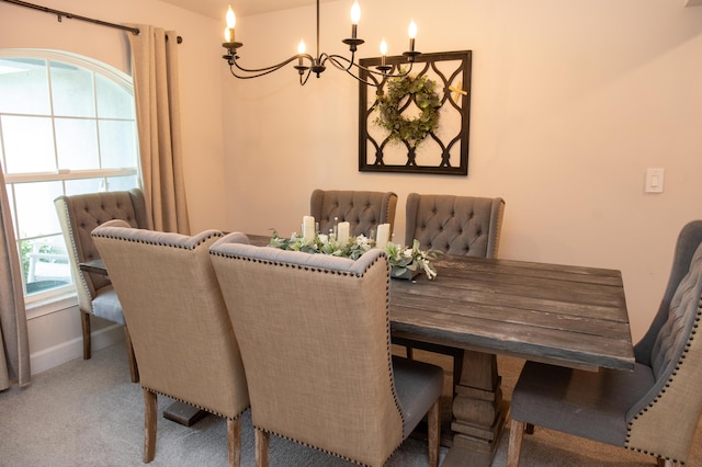 carpeted dining room featuring a chandelier