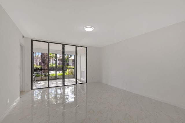 spare room featuring french doors and a wall of windows