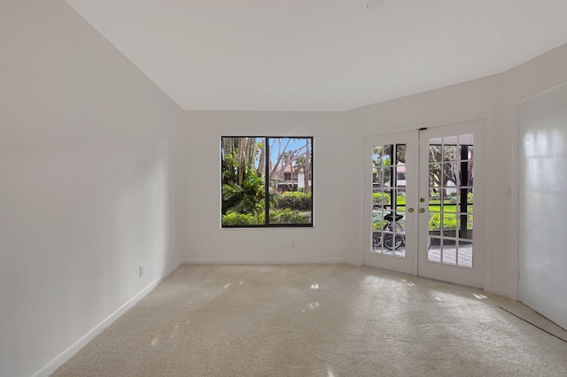 carpeted empty room featuring a wealth of natural light and french doors