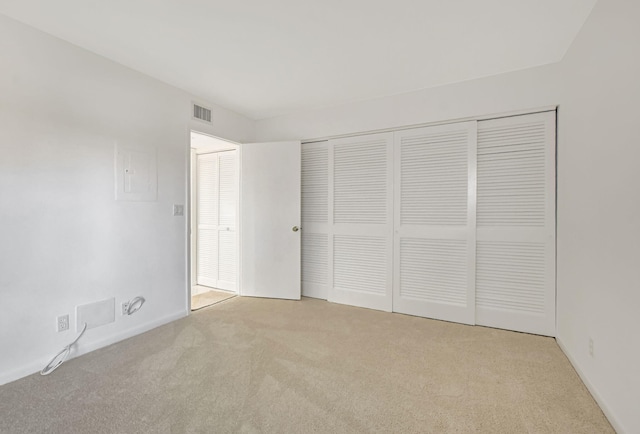 unfurnished bedroom featuring a closet and light carpet