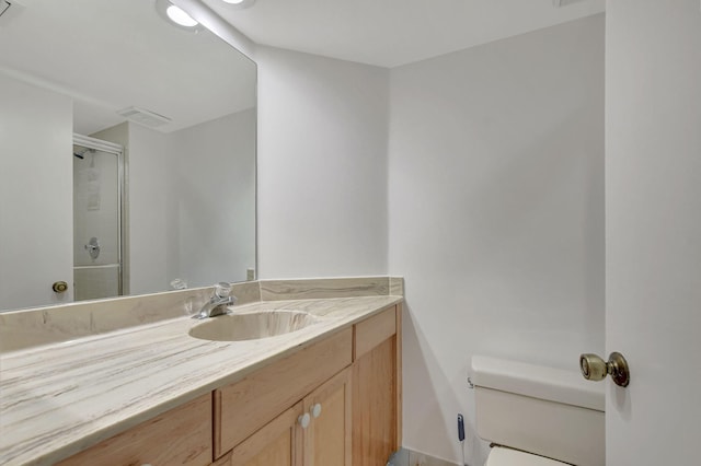 bathroom with vanity, an enclosed shower, and toilet