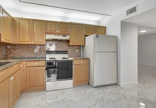 kitchen with light stone counters, white appliances, and decorative backsplash