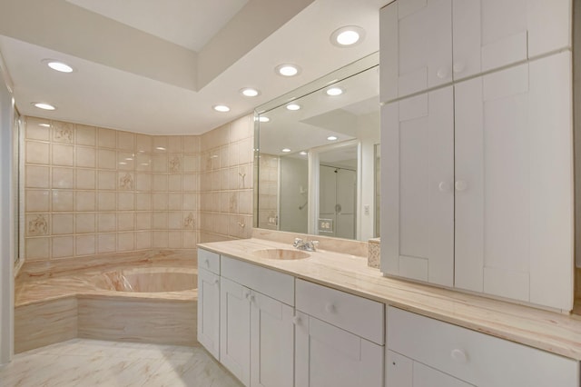 bathroom featuring vanity and tiled bath