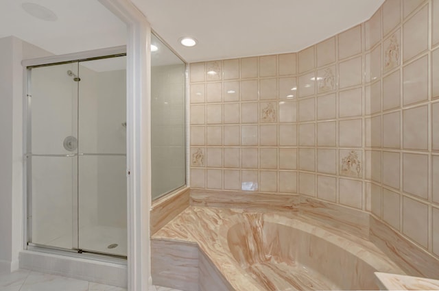 bathroom with tile walls and separate shower and tub