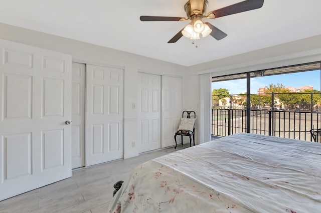 bedroom featuring access to outside, ceiling fan, and multiple closets