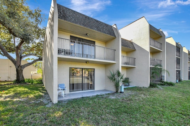 rear view of property with a lawn and a patio