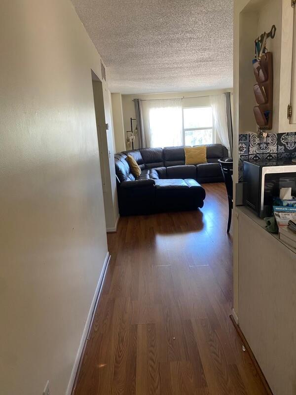 living room featuring wood-type flooring and a textured ceiling