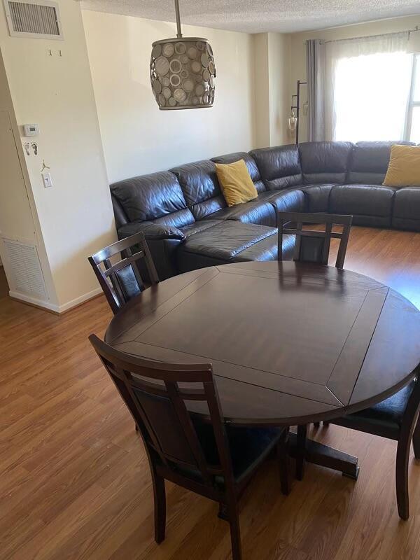 dining room with hardwood / wood-style floors and a textured ceiling